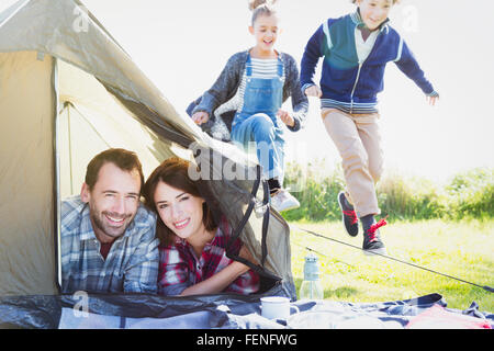 Porträt, lächelndes paar im Zelt mit Kinder spielen in der Nähe Stockfoto