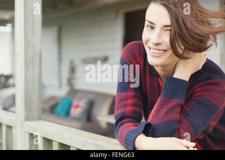 Lächelnde Brünette Frau Porträt auf Veranda Stockfoto