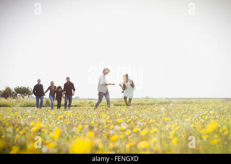 Mehr-Generationen-Familie Wandern in sonnige Wiese mit Wildblumen Stockfoto