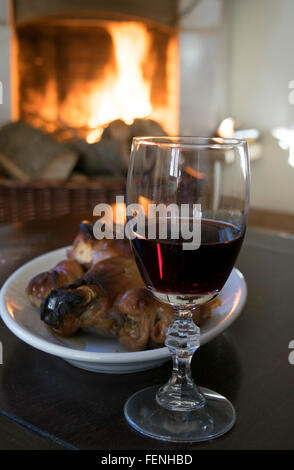 Rotwein Kelch und gebratenes Ferkel rund um den Kamin zu essen Stockfoto