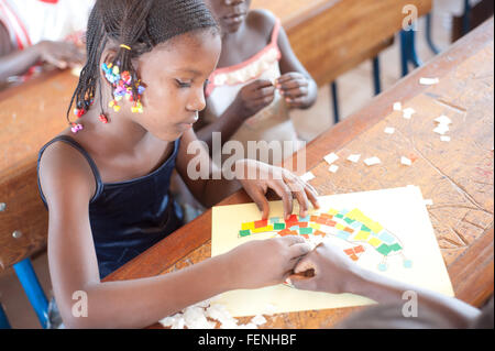Mali, Afrika - August 2009 - Closeup Portrait eines schwarzen afrikanischen Grundschule Studenten arbeiten mit einer collage Stockfoto