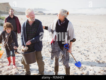 Generationsübergreifende Familie Clam Graben am Strand Stockfoto