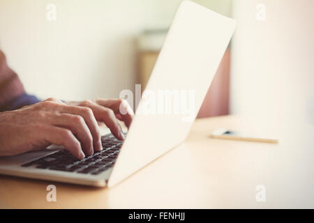 Senior woman Tippen auf Laptop am Tisch Stockfoto