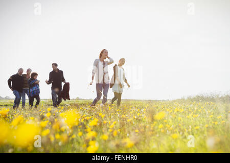 Mehr-Generationen-Familie Wandern in sonnige Wiese mit Wildblumen Stockfoto