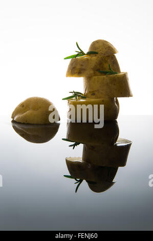 Große in Scheiben geschnittenen Kartoffeln mit Rosmarin auf Glas Stockfoto