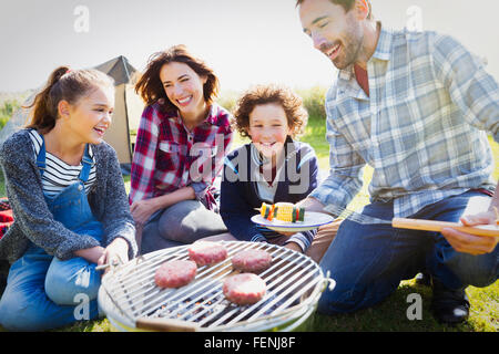 Familie Grillen auf sonniger Campingplatz Stockfoto