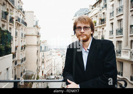 Schön ruhig bärtiger Mann tragen Kopfhörer in Paris, Frankreich in die Kamera schauen. City-Lifestyle. Stockfoto