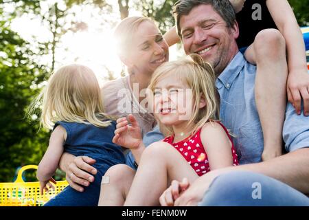 Glückliche Eltern und drei Töchter teilen Familien-Picknick im park Stockfoto