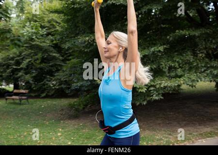 Reife Frau Hand Gewichte zu heben, beim training im park Stockfoto