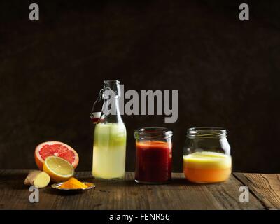 Rohen Saft in Glasflaschen und Gläser, dunklen Hintergrund Stockfoto