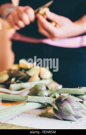 Männliche Hände Zubereitung Artischocken in Küche Stockfoto