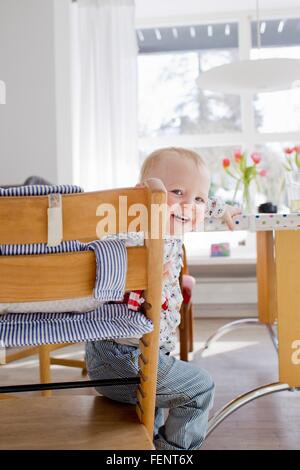 Porträt von weiblichen Kleinkind sitzen über die Schulter schauen Stockfoto