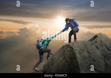 Kletterer helfen Partner erreichen Berggipfel, Mont Blanc, Frankreich Stockfoto