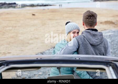 Junges Paar mit Arme umeinander an Strand, Konstantin Bay, Cornwall, UK Stockfoto