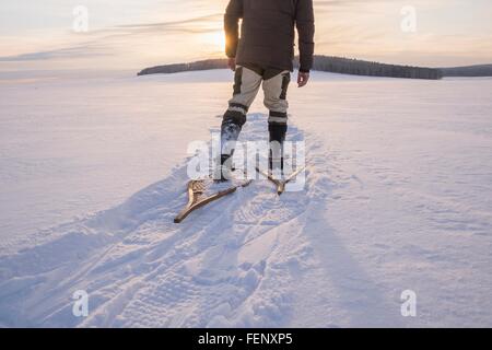 Rückansicht des männlichen Wanderer wandern über Schnee bedeckt Landschaft, Ural, Russland Stockfoto