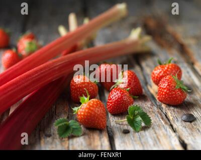 Rhabarber und Erdbeeren auf Holzoberfläche Stockfoto