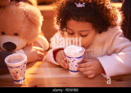 Vogelperspektive Blick auf Mädchen und Teddybär trinken heißen Schokolade, Blick nach unten Stockfoto