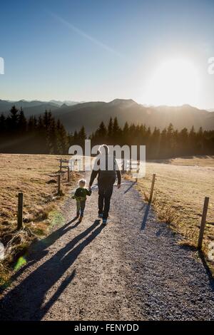 Rückansicht des Mannes und Kleinkind Tochter gehen auf Feldweg, Tegernsee, Bayern, Deutschland Stockfoto