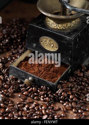 Frisch gemahlenen Kaffee im Vintage Kaffeemühle und rohen Kaffeebohnen Stockfoto