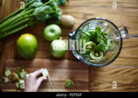 Frauenbeschneidung grün Kiwi auf Holztisch Stockfoto