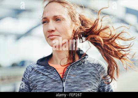 Porträt von weiblichen Läufer mit Überseerennen Haar auf Stadt-Steg Stockfoto