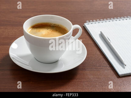 Tasse aromatischen Kaffee Americano mit Notizblock und Stift. Stockfoto