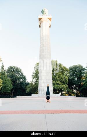 Frau macht Kopfstand (Salamba Sirsasana), Prison Ship Martyrs Denkmal, Fort Greene Park, New York, USA Stockfoto