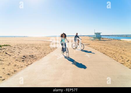 Paar Radfahren entlang Weg am Strand Stockfoto