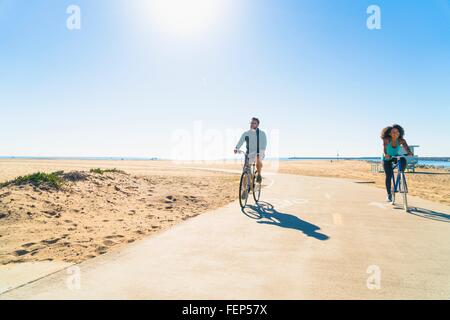 Paar Radfahren entlang Weg am Strand Stockfoto