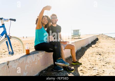 Paar, sitzen auf Wand Selbstporträt mit smartphone Stockfoto