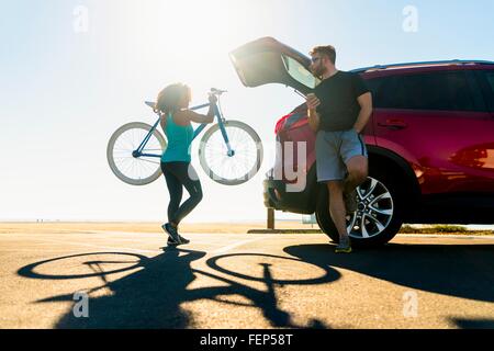 Mitte Erwachsene Frau, Fahrrad in Kofferraum Stockfoto