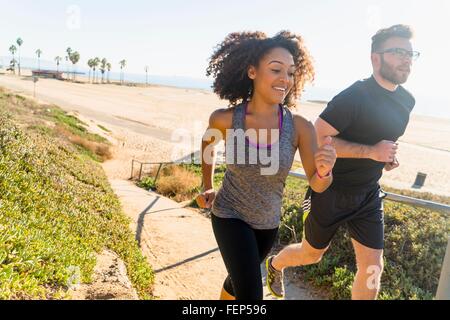 Paar laufen weg vom Strand Stockfoto