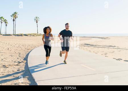 Paar auf Weg am Strand laufen Stockfoto