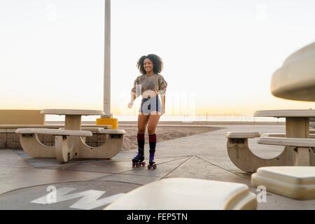Mitte Erwachsene Frau auf Skates, in der Nähe von Strand Stockfoto