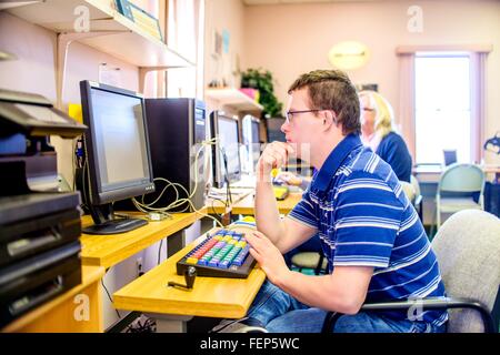 Junger Mann mit Down-Syndrom, lernen am computer Stockfoto