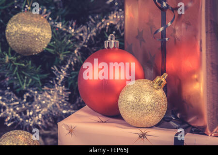 Glänzende Weihnachtskugeln mit Geschenken in goldenen Verpackung Stockfoto