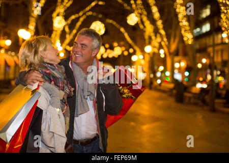 Älteres Paar tragen Weihnachtsansturm auf Baum gesäumten Allee, Mallorca, Spanien Stockfoto