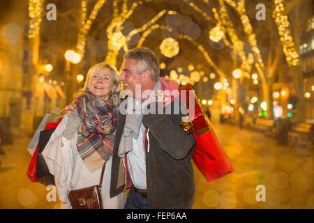 Reifen Sie paar Xmas shopping auf Bäumen gesäumten Allee, Mallorca, Spanien Stockfoto