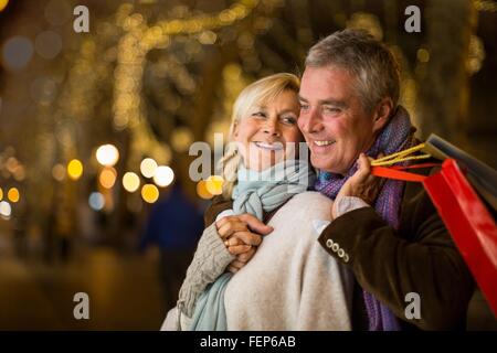 Porträt des reifes Paar mit Xmas shopping auf Bäumen gesäumten Allee, Mallorca, Spanien Stockfoto