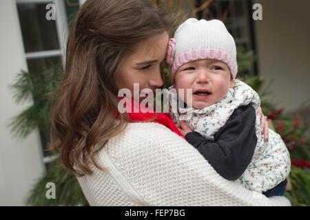 Junge Mädchen weint, wird getröstet durch die Mutter, im freien Stockfoto