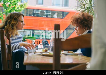 Zwei Freundinnen Essen und plaudern im café Stockfoto