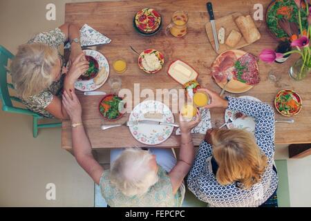 Drei Frauen, die dem gemeinsamen Mittagessen zu Hause, Draufsicht Stockfoto