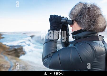 Frau mit dem Fernglas Gullfoss Wasserfall, befindet sich in den Canyon des Hvita Fluss in South West Island ansehen Stockfoto