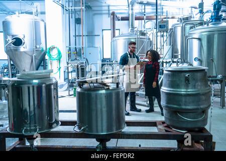 Kollegen in Brauerei stehend betrachten Zwischenablage Stockfoto