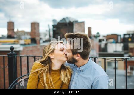 Romantische junge Paar küssen auf Stadt-Dachterrasse Stockfoto
