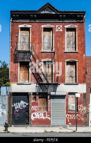 Altersschwaches altes Haus mit roten Ziegeln und Graffiti in Queens (New York) Stockfoto