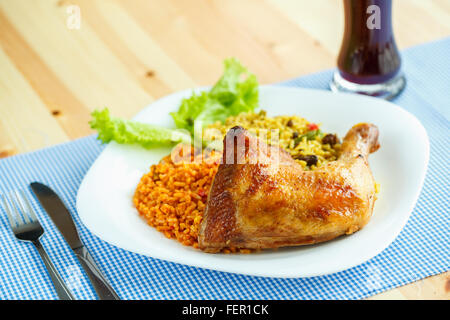 Schmackhaftes Gericht Hühnerkeule mit Reis und Salat Blätter Stockfoto