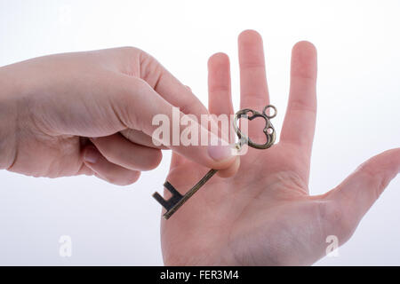 Hand, die einen Retro-Stilen Schlüssel Stockfoto