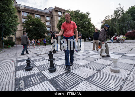 Gruppe der Männer spielen Schach auf dem großen Schachbrett am Trg Oslobodjenja (Platz der Befreiung) in Sarajevo, Bosnien und Herzegowina Stockfoto