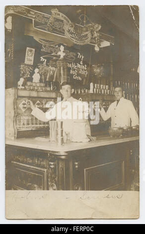 Eine Vintage-RPPC (Real Photo Postcard) mit einer Szene zu Hohns-Sowers und Soda Fontänen, insbesondere Coca-Cola und Dr. Pepper. Das Bild zeigt eine amerikanische Kulturszene aus dem frühen 20. Jahrhundert mit beliebten Soda-Marken. Stockfoto